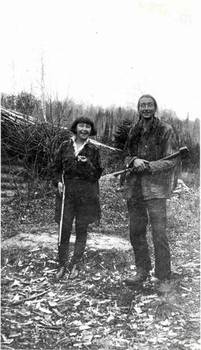 Grey Owl and Anahareo at Squatech, Temiscouata holding shot gun and ax, 1929. Credit: University of Saskatchewan Archives, JGD/MG01/XVII/JGD 2802.